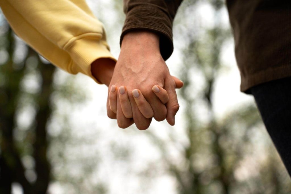 Close-up of a couple holding hands in Fort Lauderdale, Florida, symbolizing unity and support, representing the compassionate approach of Judith Ramos, Attorney at Law to alimony and spousal support cases.