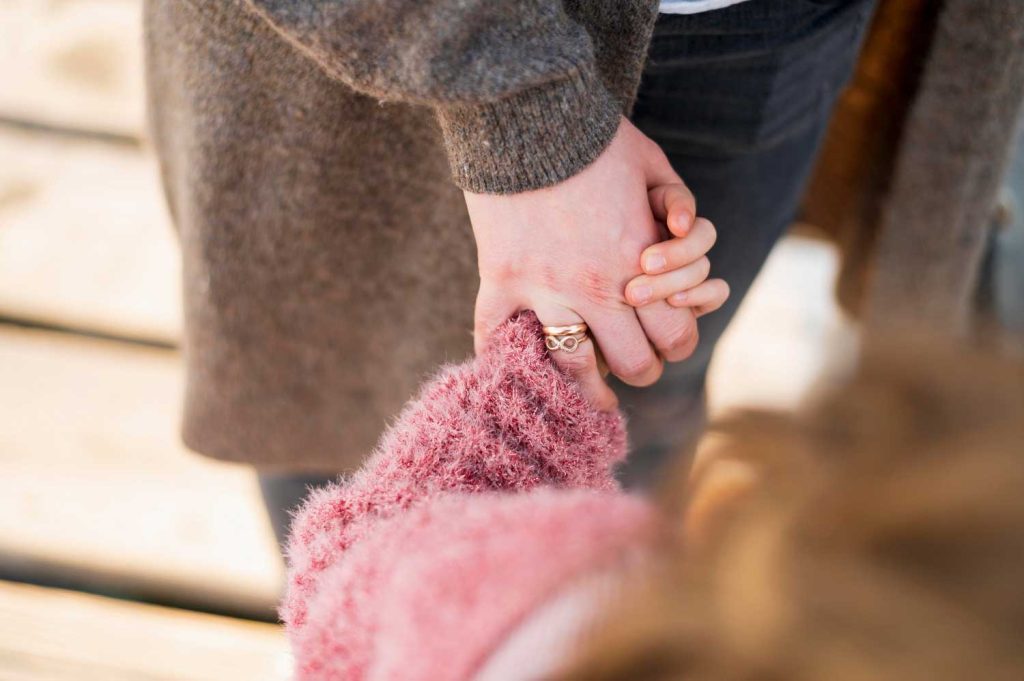 A close-up of a parent holding a child’s hand, representing emotional support and connection in child custody cases managed by Judith Ramos, Attorney at Law in Fort Lauderdale, Florida.